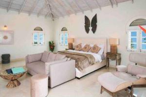 1 dormitorio con cama, sofá y sillas en Luxury 4 bed villa in Mullins St Peter - Sugar Palm House, en Saint Peter