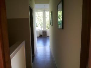 a hallway with a tile floor and two pictures on the wall at Fishermen's Guesthouse in Amed
