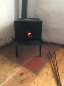 una estufa negra con chimenea en una habitación en Guesthouse AISI in Lagodekhi en Lagodekhi