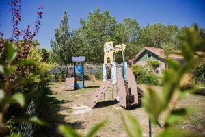 um parque infantil com um escorrega num quintal em Lodges Méditerranée em Vendres-Plage