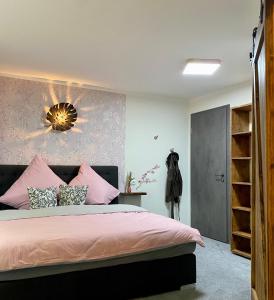 ein Schlafzimmer mit einem rosa Bett und einer Wand mit einem Spiegel in der Unterkunft Brauhaisla in Konradsreuth