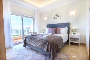 una camera con un grande letto e una grande finestra di Casa da Boa Vida at Boa Vista Golf Resort Bayview a Lagos
