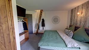 1 dormitorio con cama verde y pared en Brauhaisla, en Konradsreuth