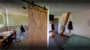 baño con puerta de madera y lavamanos en Brauhaisla en Konradsreuth