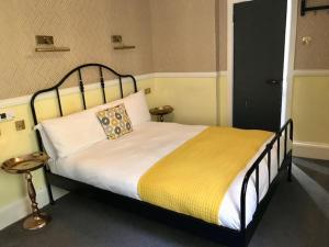 a bedroom with a large bed with a yellow blanket at Lunan House in Arbroath