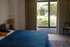 a bedroom with a bed and a large window at Bungalow 89 by StayVista - A hill-view villa adorned with eclectic interiors for a truly unique & captivating stay in Lonavala +19 photos