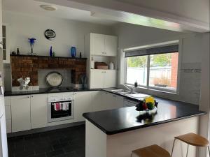 a kitchen with white cabinets and a black counter top at Resonance in Lucknow