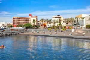 a group of people swimming in the water at a beach at Isla Bonita San Juan Beach in Guía de Isora