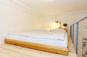a bedroom with a large bed with white sheets at Urban Art Kreuzberg in Berlin