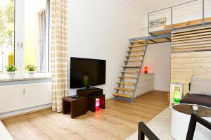 a living room with a flat screen tv and a staircase at Urban Art Kreuzberg in Berlin