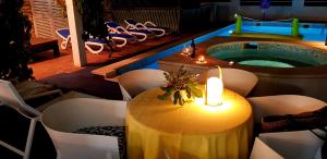 ein Tisch mit einer Kerze neben einem Swimmingpool in der Unterkunft Villa Lucia with private pool and a whirlpool in Vis
