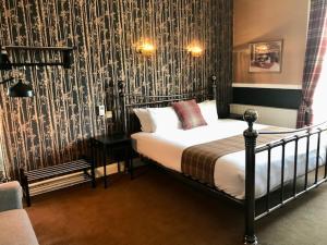 a bedroom with a bed with a patterned wall at Lunan House in Arbroath