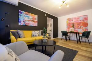 a living room with a yellow couch and a table at Lemonade - Stylish 1BR Apartment in Obor District in Bucharest