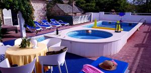 a pool with a hot tub with chairs and a table at Villa Lucia with private pool and a whirlpool in Vis