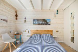 Un dormitorio con una cama azul y blanca y una silla en Au Petit Pédegouaty, en Heugas