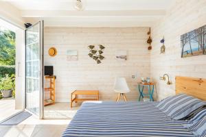 - une chambre avec un lit et une porte coulissante en verre dans l'établissement Au Petit Pédegouaty, à Heugas