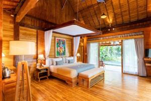 a bedroom with a bed in a room with wooden walls at Govinda Villas in Penginyahan