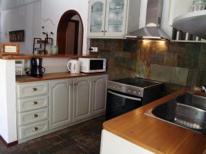 a kitchen with white cabinets and a sink at artística in Ermioni