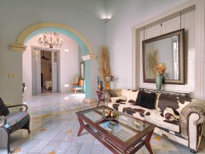 Casona 66 Merida Boutique Hotel في ميريدا: غرفة معيشة مع أريكة وطاولة قهوة