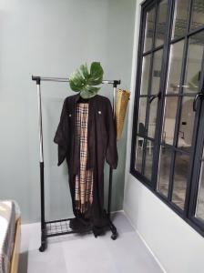 a coat hanging on a rack next to a window at Shared flat in an artists district Pikris Gora in Tbilisi City