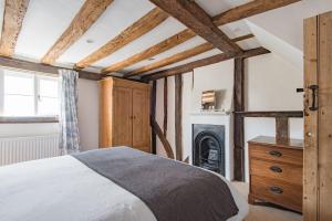 um quarto com uma cama e uma lareira em Farriers Cottage by Bloom Stays em West Malling