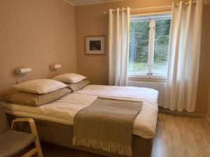 1 dormitorio con 1 cama grande y ventana en Fulufjällsgården en Mörkret
