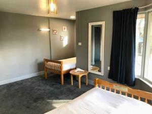 a bedroom with a bed and a bench and a mirror at Lunan House in Arbroath