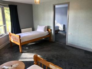 a bedroom with a bed and a room with a table at Lunan House in Arbroath
