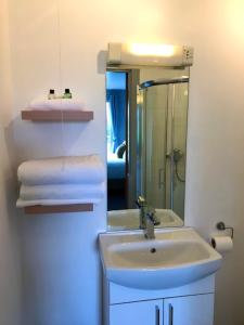 a bathroom with a sink and a mirror and towels at Lunan House in Arbroath