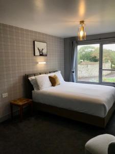 a bedroom with a large bed and a window at Lunan House in Arbroath