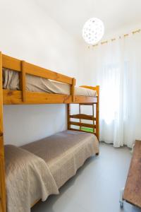 2 Etagenbetten in einem weißen Zimmer mit Fenster in der Unterkunft Villa Maria una finestra sul mare in Valderice