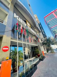 una fachada de un edificio con banderas delante en Kiev Tower Hotel Apartments, en Manama