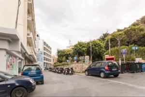a street with cars and motorcycles parked on the street at Cozy Apartment In The Heart Of The City in Heraklio Town