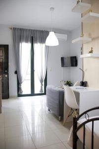 ein Wohnzimmer mit einem Bett, einem Tisch und einem Schreibtisch in der Unterkunft Cozy Apartment In The Heart Of The City in Iraklio