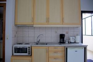 eine Küche mit einer Spüle und einer Mikrowelle in der Unterkunft Cozy Apartment In The Heart Of The City in Iraklio