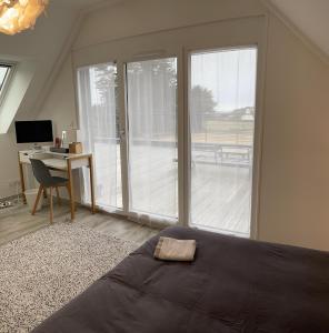 Schlafzimmer mit einem Bett und einem Schreibtisch mit einem Computer in der Unterkunft Ty Marie Neiz Vran - Villa luxe vue mer, 80 mètres de la plage in Kerlouan