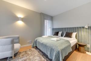 a bedroom with a bed and a chair at Flatbook - City Center SPA Apartments Motlawa in Gdańsk