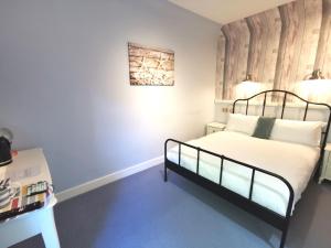 a bedroom with a bed with a wooden headboard at Lunan House in Arbroath