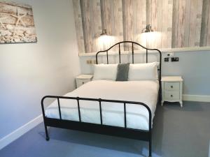 a bedroom with a bed with white sheets and pillows at Lunan House in Arbroath