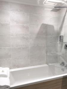 a bathroom with a bath tub and a sink at Lunan House in Arbroath