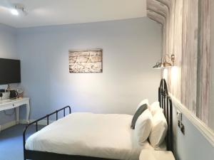 a bedroom with a bed with white sheets at Lunan House in Arbroath