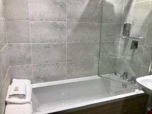 a bathroom with a bath tub and a sink at Lunan House in Arbroath