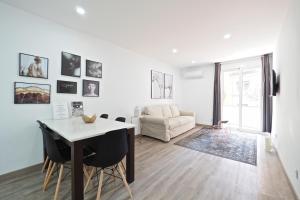 un soggiorno bianco con tavolo e sedie di The White Flats Les Corts a Barcellona