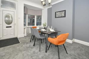 uma sala de jantar com mesa e cadeiras em Victoria House by YourStays, City Centre, free parking, sleeps 6 em Stoke-on-Trent