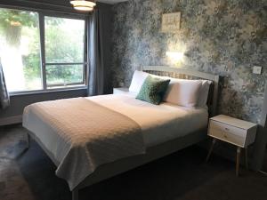 a bedroom with a large bed with a window at Lunan House in Arbroath