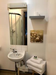 a white bathroom with a sink and a mirror at Lunan House in Arbroath