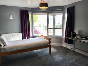 a bedroom with a bed and a large window at Lunan House in Arbroath