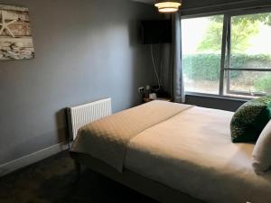a bedroom with a large bed and a window at Lunan House in Arbroath