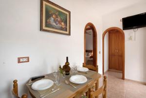 a dining room with a table with plates and a television at Casa Nanda in Fasnia