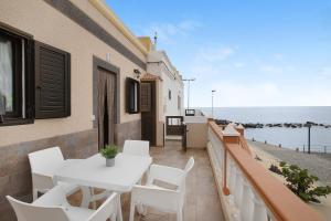 einen Balkon mit einem weißen Tisch, Stühlen und Meerblick in der Unterkunft Casa Nanda in Fasnia